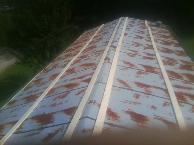 Rusted metal roof panels with new wood purlins before replacement — Storm Damage Roof Repair in Sloan by Roofing Brothers