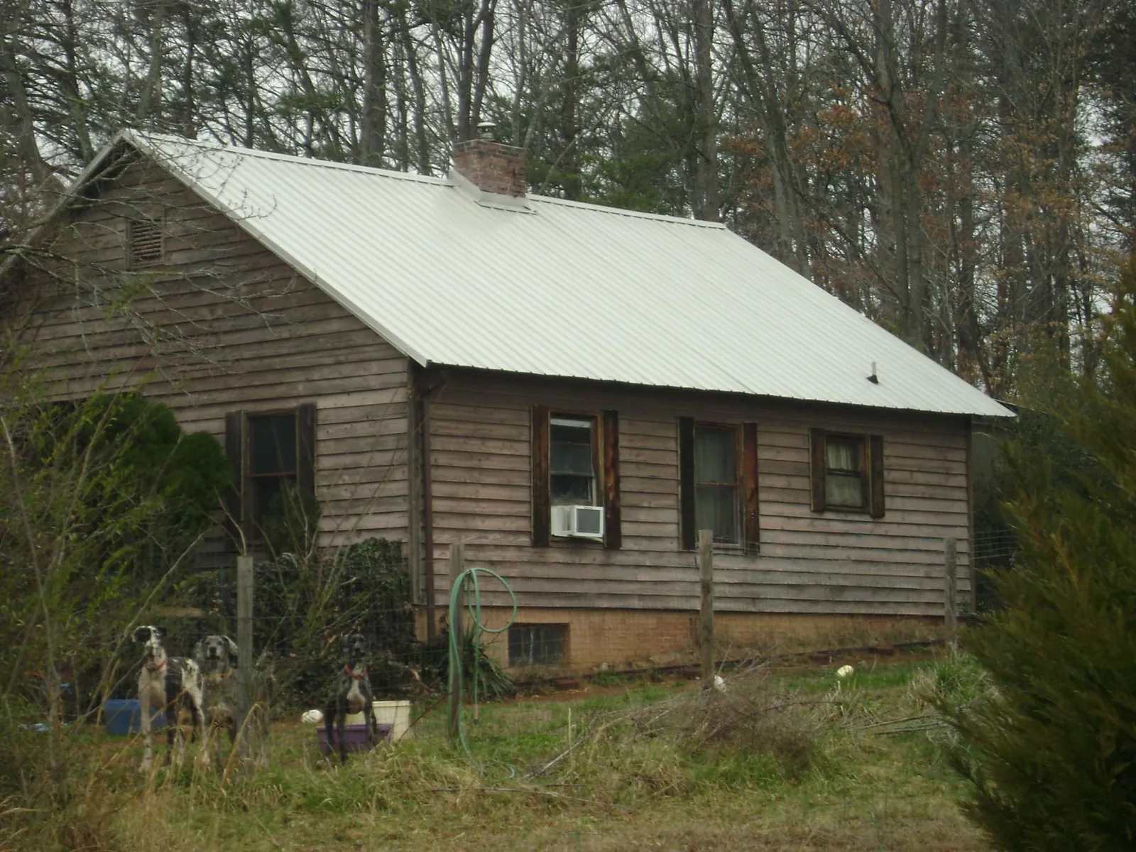 White metal roof on an old wood sided farmhouse, from a Metal Roof Installation job in Sloan